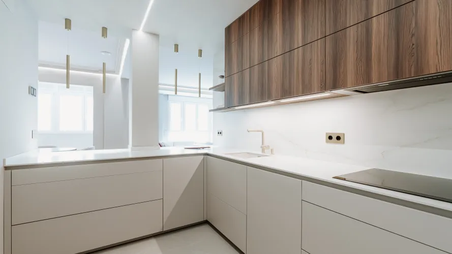 Cocina contemporánea con madera oscura, tonos neutros y detalles dorados