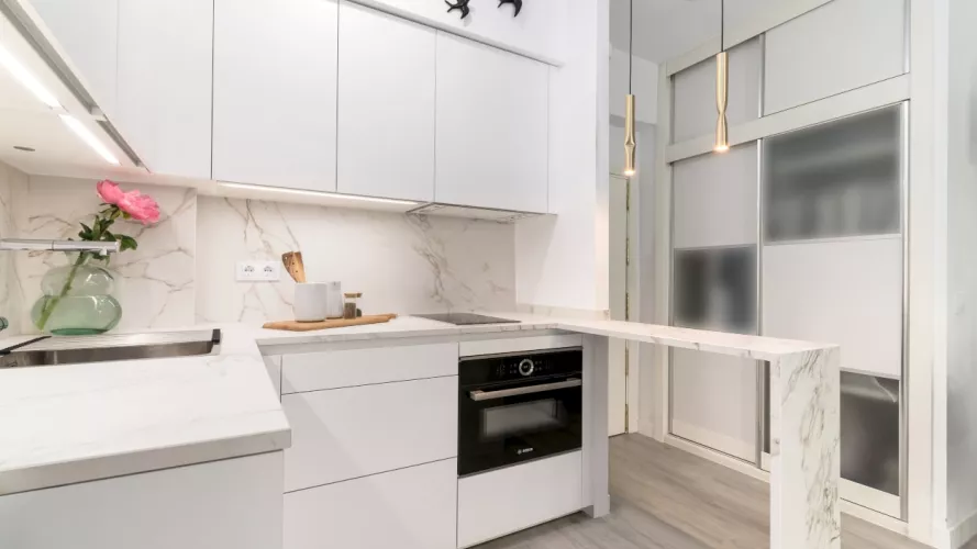 Cocina Santos blanca con barra y encimera Dekton