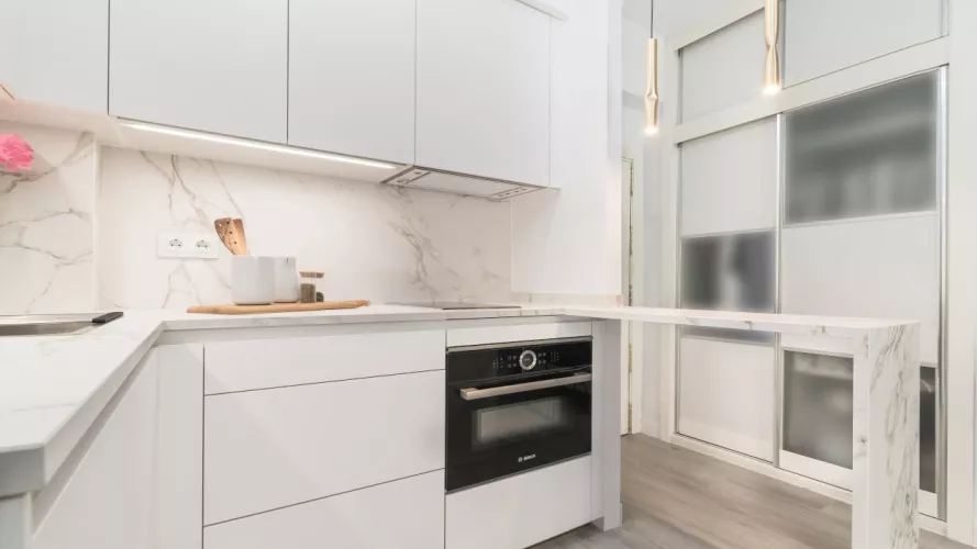 Cocina Santos blanca con barra y encimera Dekton