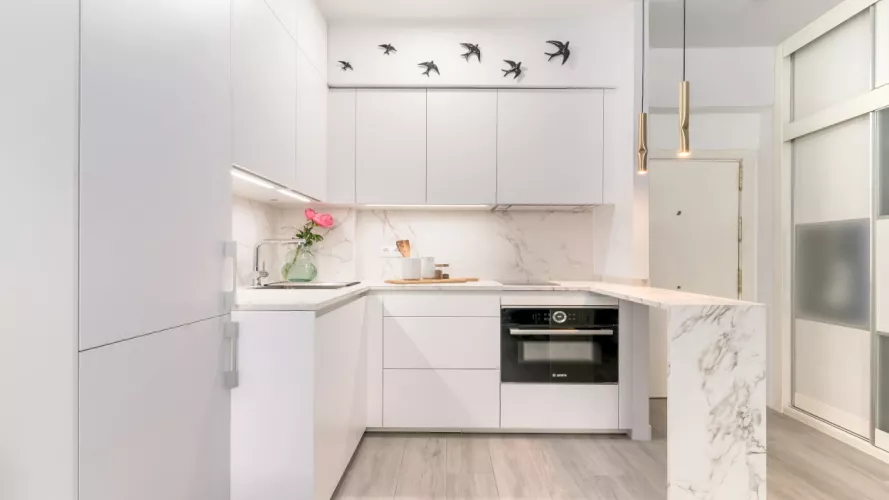 Cocina Santos blanca con barra y encimera Dekton