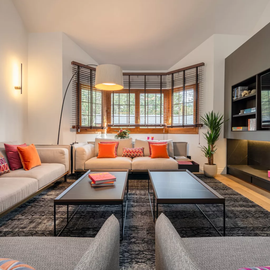 Salón contemporáneo de doble altura con atmósfera cálida y carácter arquitectónico