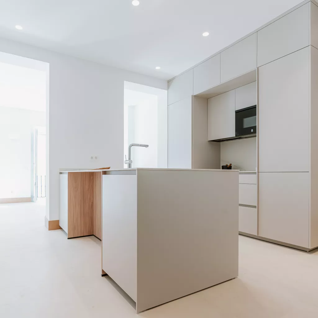 Cocina blanca con isla central y detalles en madera: amplitud, equilibrio y funcionalidad