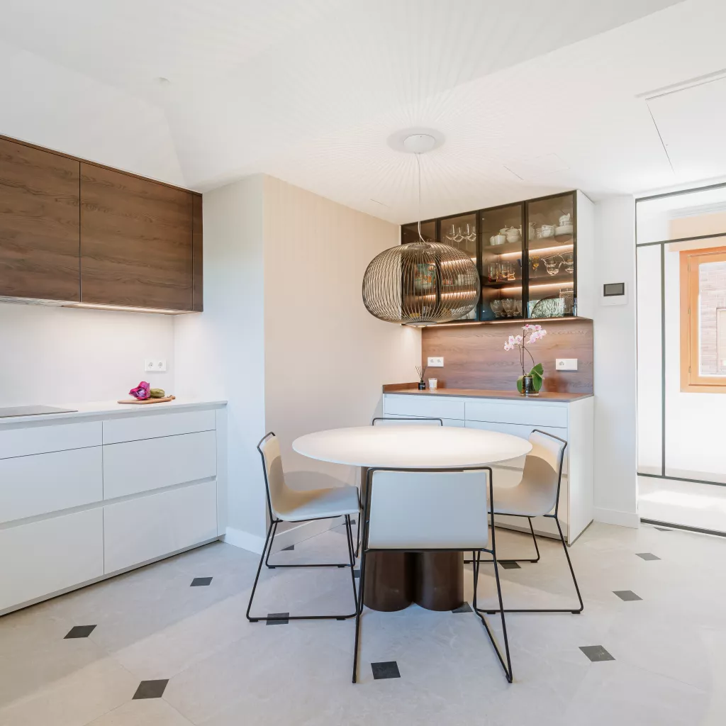 Cocina blanca con madera oscura y vitrinas iluminadas: equilibrio, calidez y funcionalidad