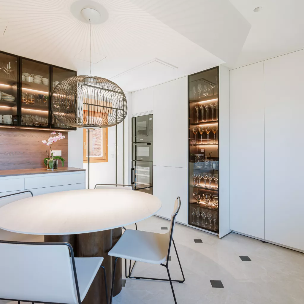 Cocina blanca con madera oscura y vitrinas iluminadas: equilibrio, calidez y funcionalidad
